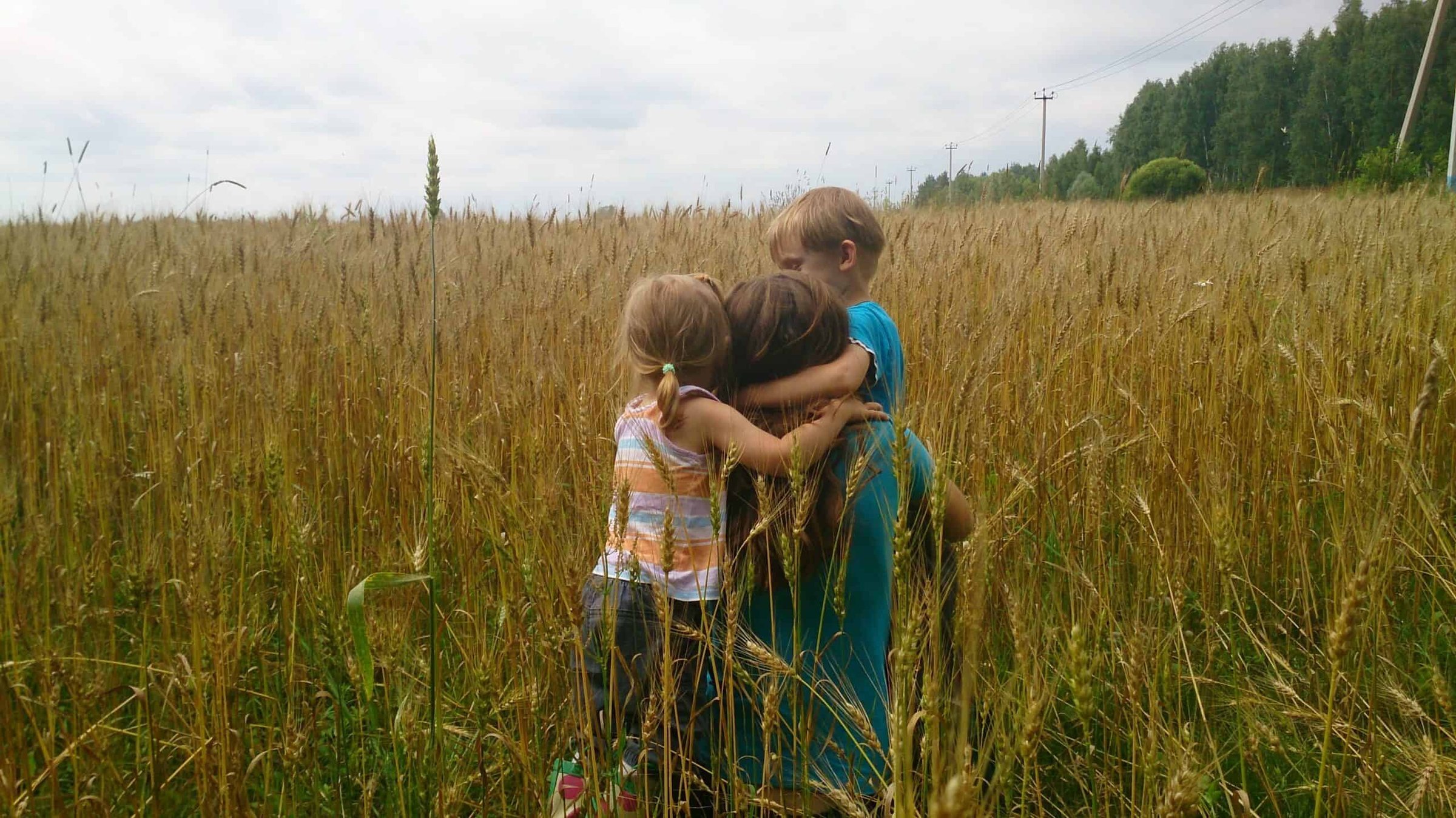 children-hugging-mother-sitting-in-the-field-2024-12-01-13-09-35-utc-scaled