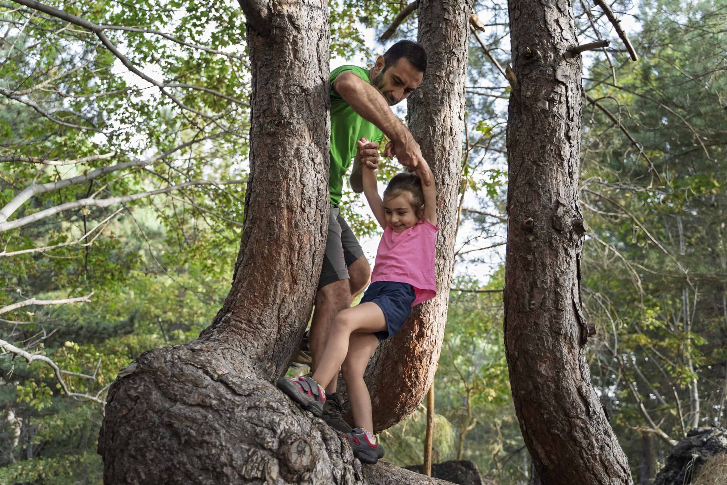 father-helping-daughter-climb-tree-during-outdoor-2025-04-29-03-50-35-utc-scaled