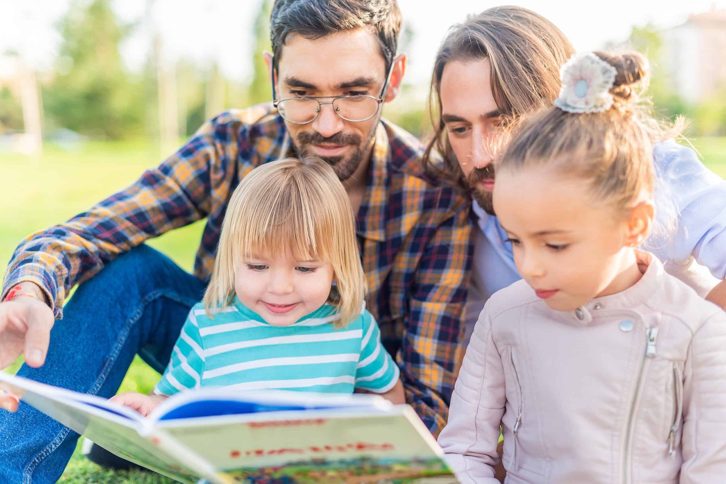 gay-male-couple-with-their-children-reading-a-book-2025-02-16-04-10-16-utc-scaled