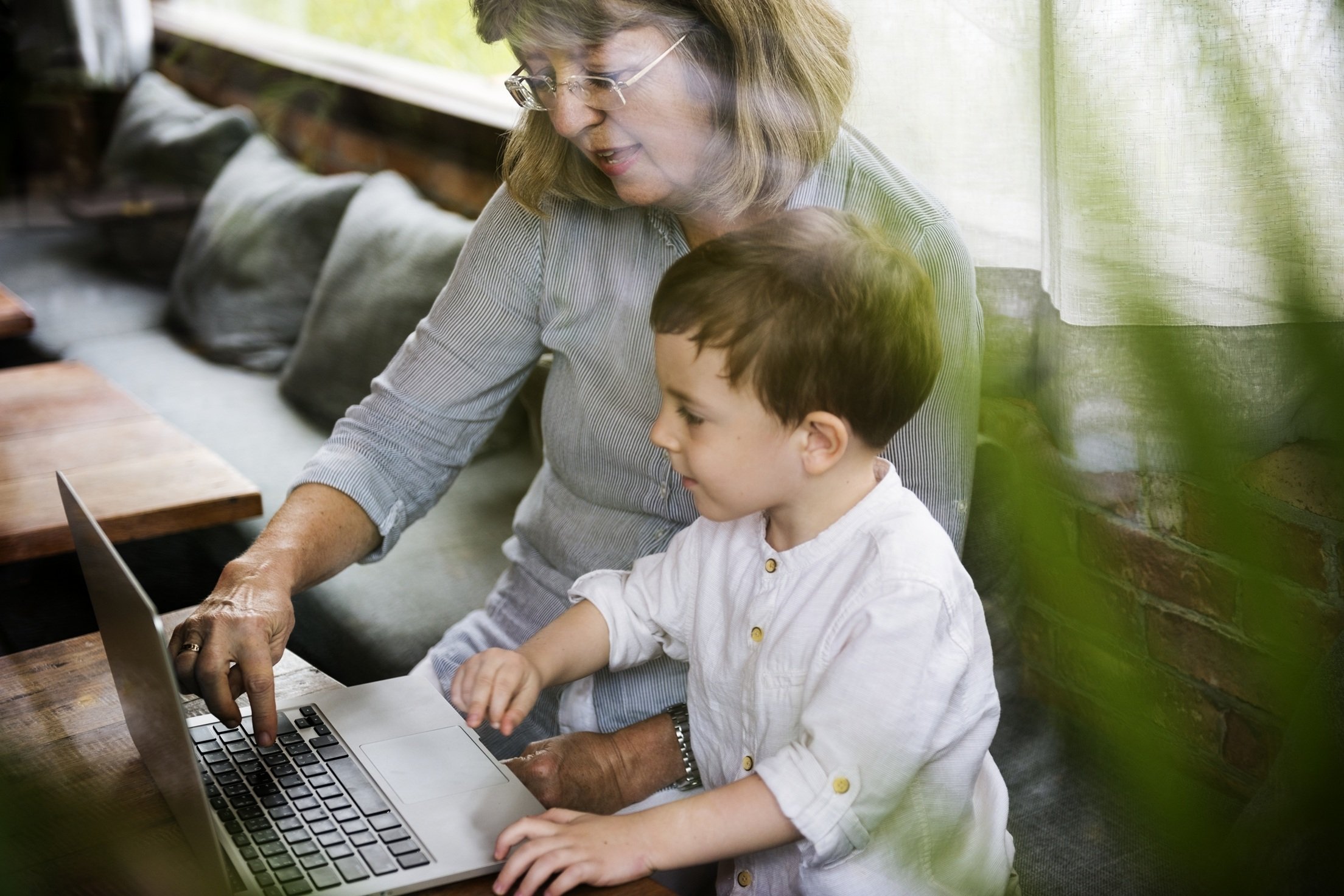 grandmother-and-grandson-using-laptop-together-ind-2026-03-18-12-13-34-utc