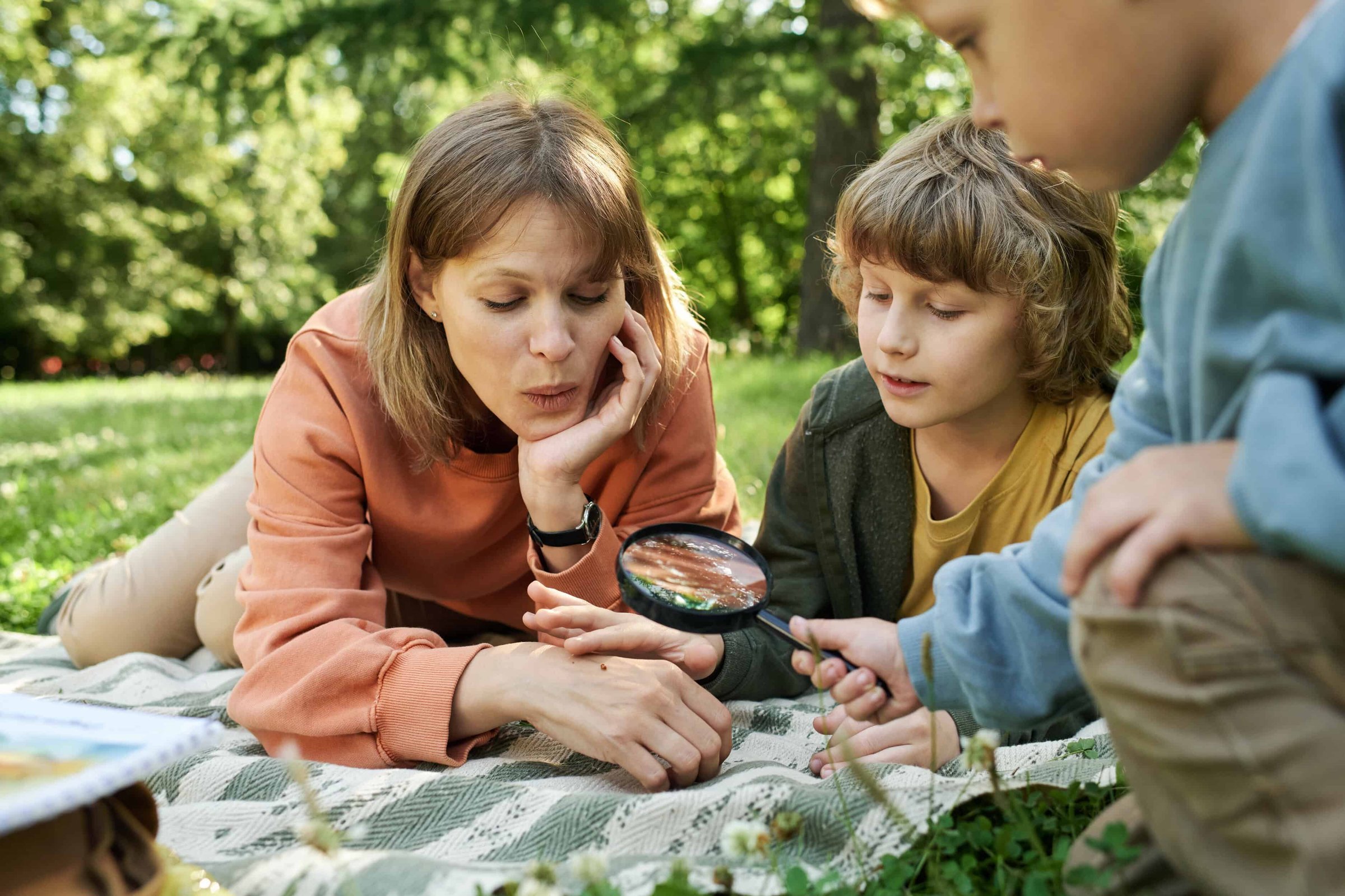 happy-family-in-park-and-using-magnifying-glass-2025-06-05-23-25-01-utc