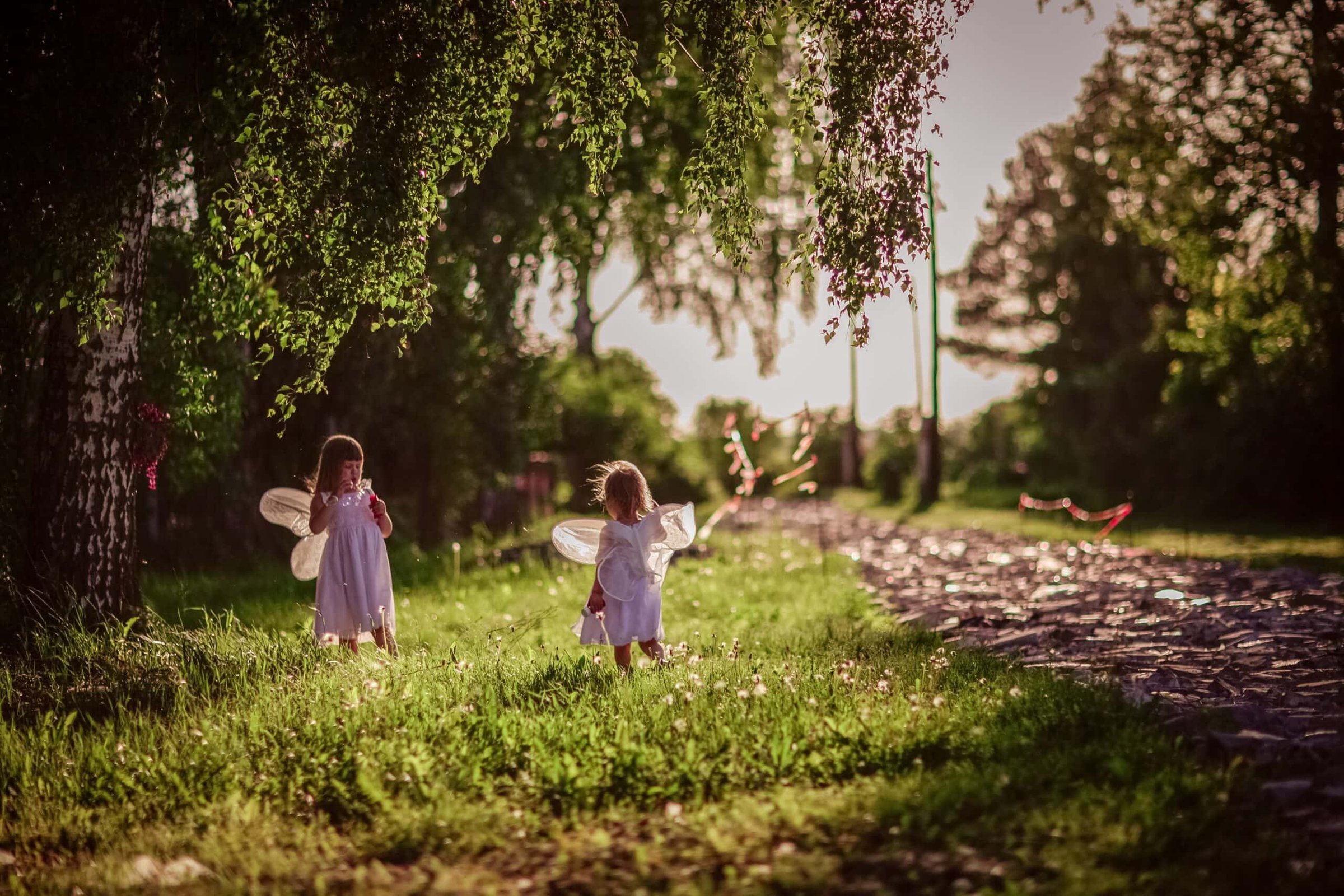 magic-children-sisters-with-toy-wings-play-in-the-2024-10-12-03-29-27-utc-scaled