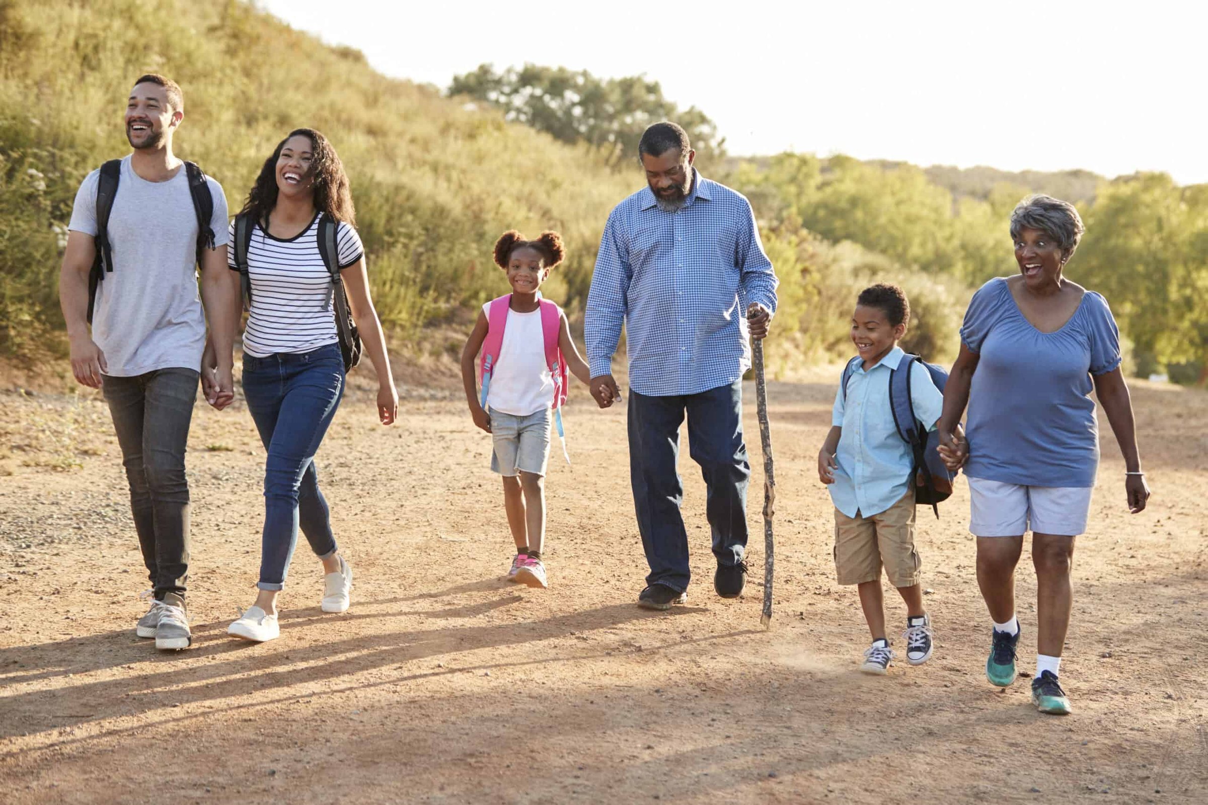 multi-generation-family-wearing-backpacks-hiking-