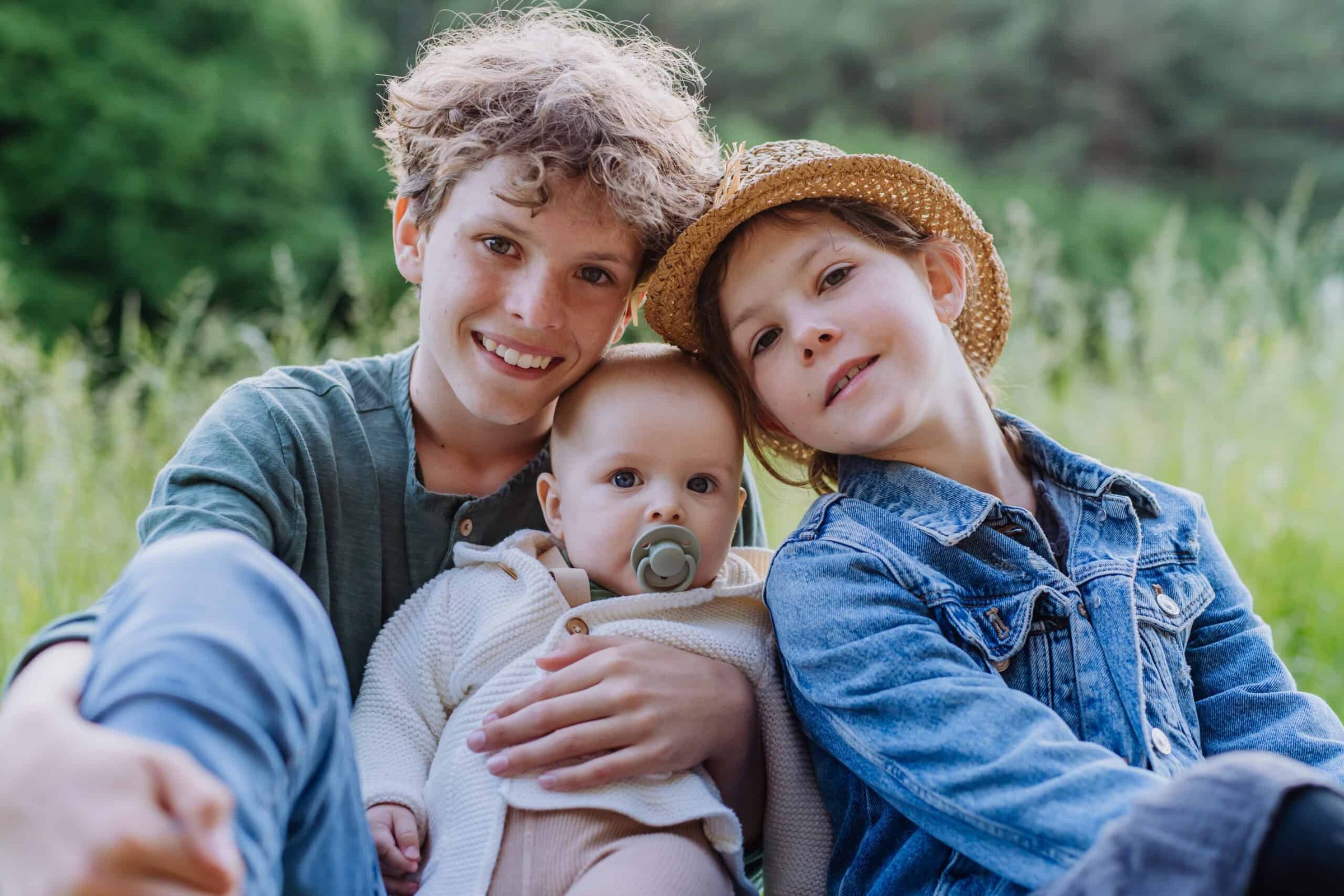 portrait-of-three-children-sitting-in-a-grass-hav-2024-10-21-12-52-09-utc-scaled