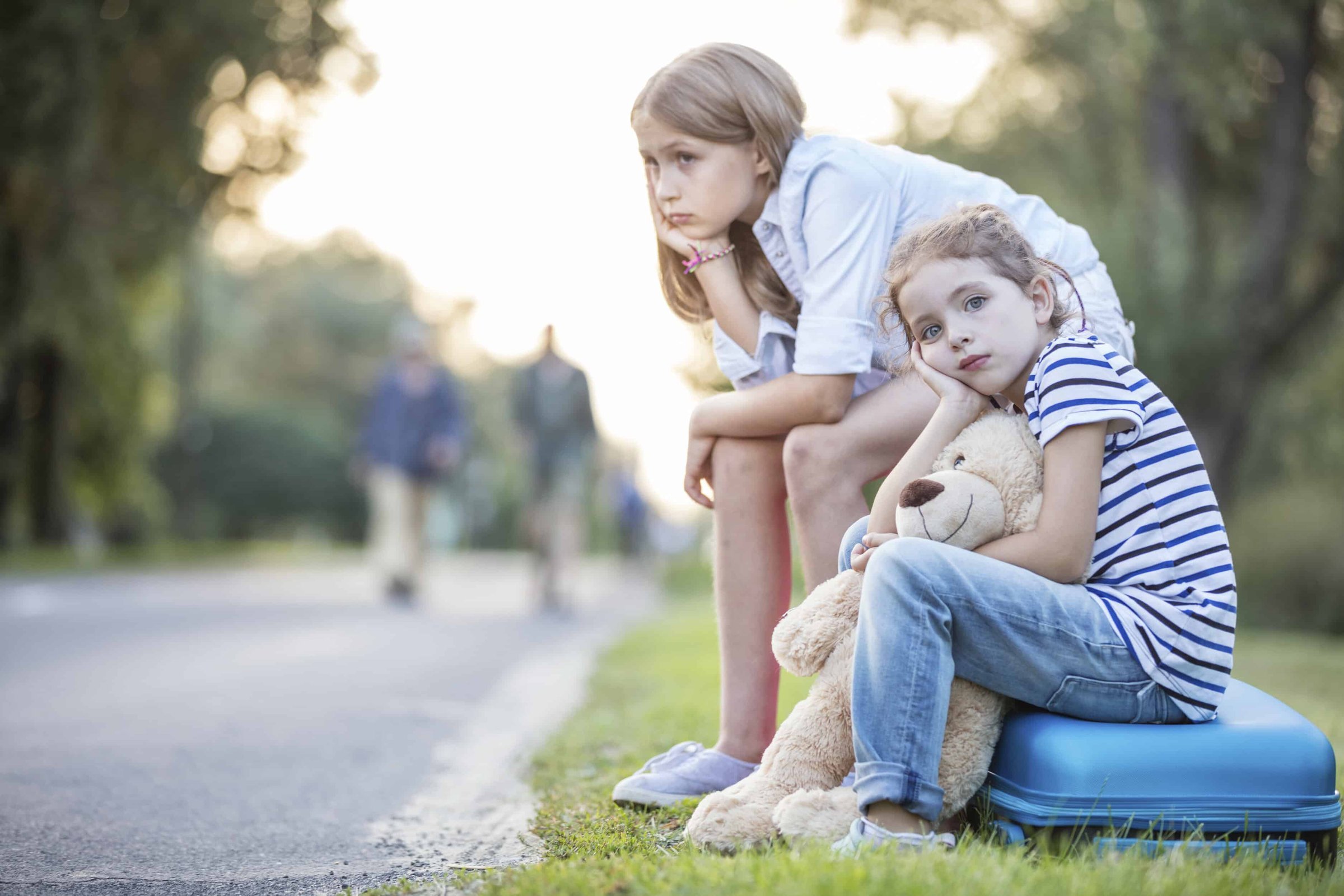 two-girls-sitting-on-suitcase-at-the-roadside-2024-09-18-22-28-23-utc