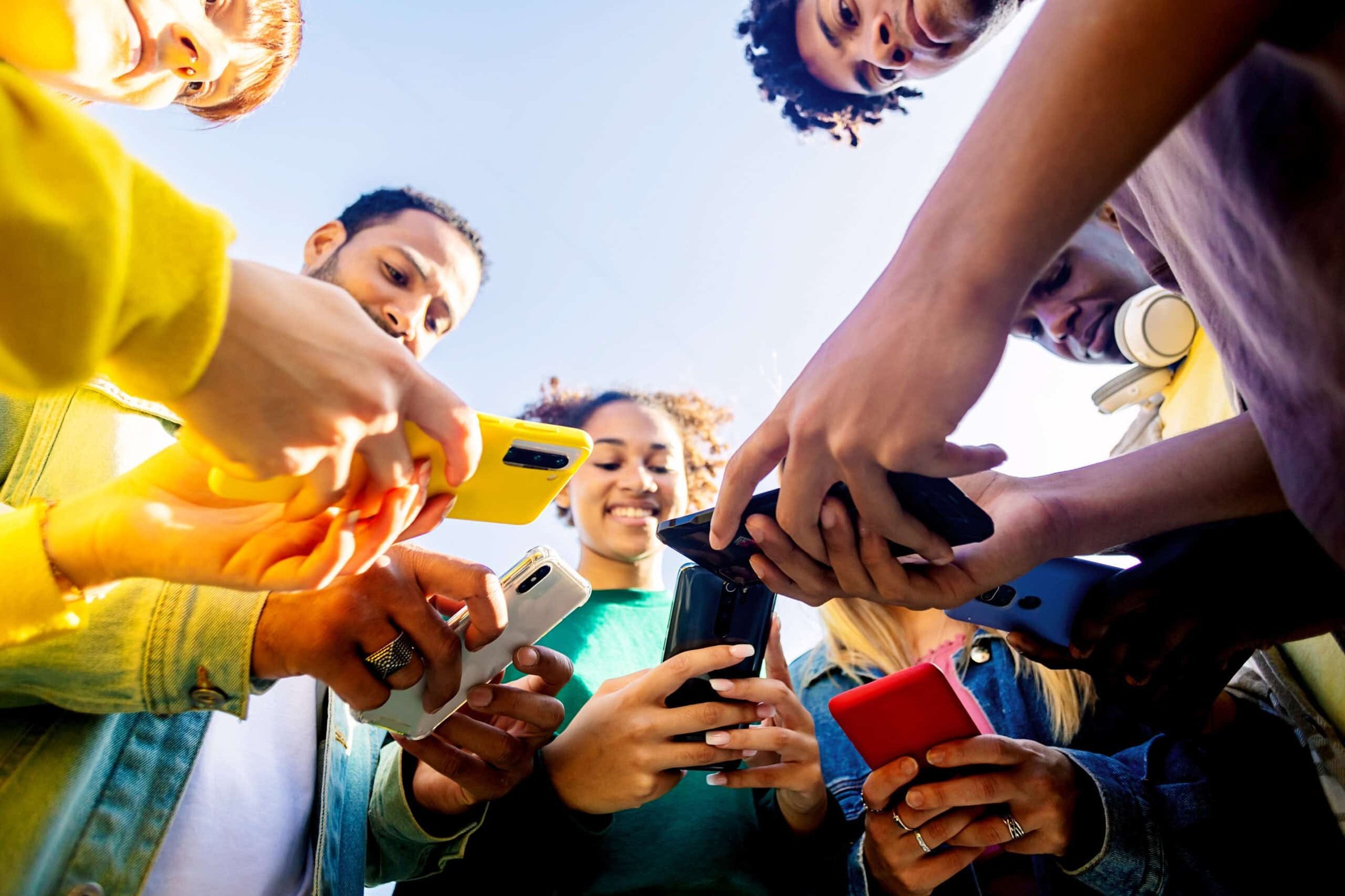 young-group-of-people-using-mobile-phone-outdoors-2024-04-29-19-50-42-utc-scaled